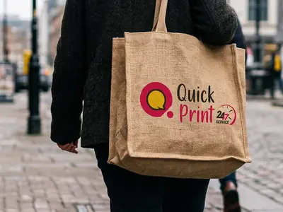 Screen-printed jute tote bag carried over the shoulder on a city street, Hyderabad