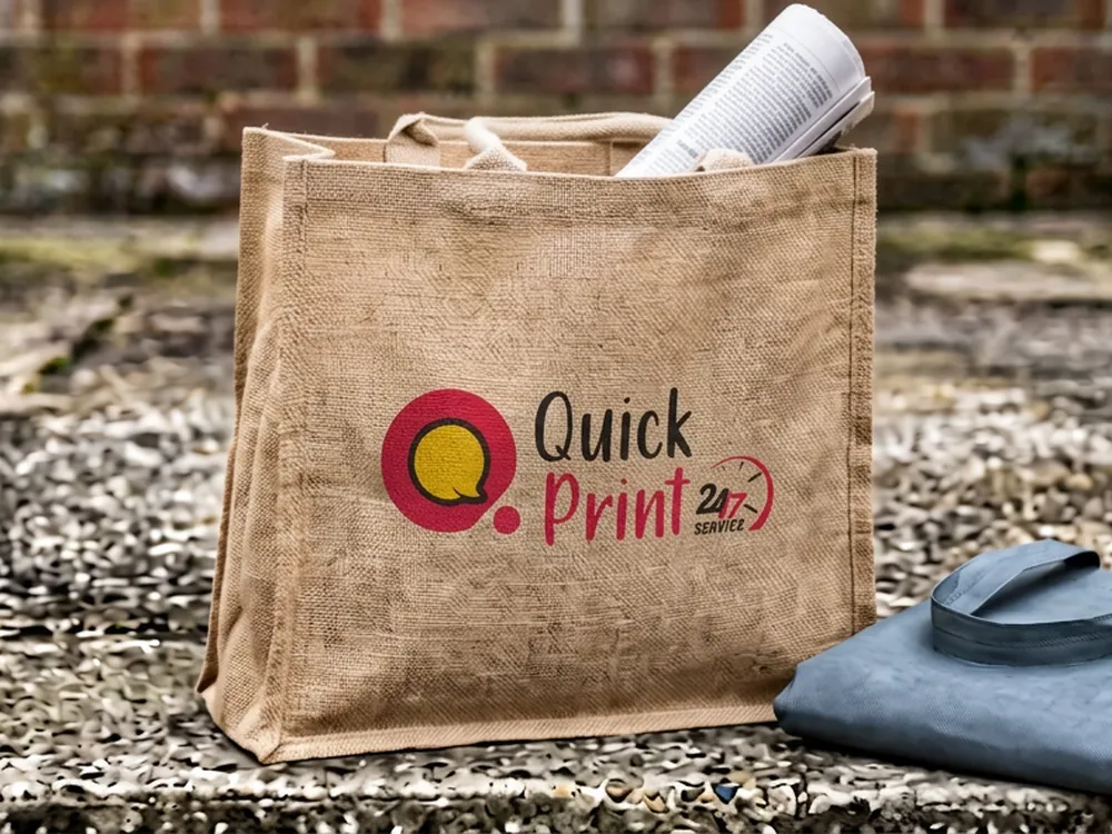Screen-printed jute tote bag and non-woven bag on a concrete step, printed in Hyderabad