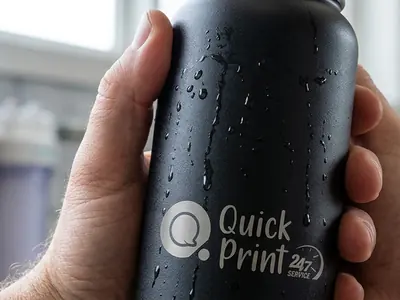 Hand holding a laser-etched matte black steel bottle with condensation, Hyderabad