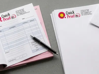 Open NCR carbonless bill book with letterheads and envelope on a desk, printed in Hyderabad